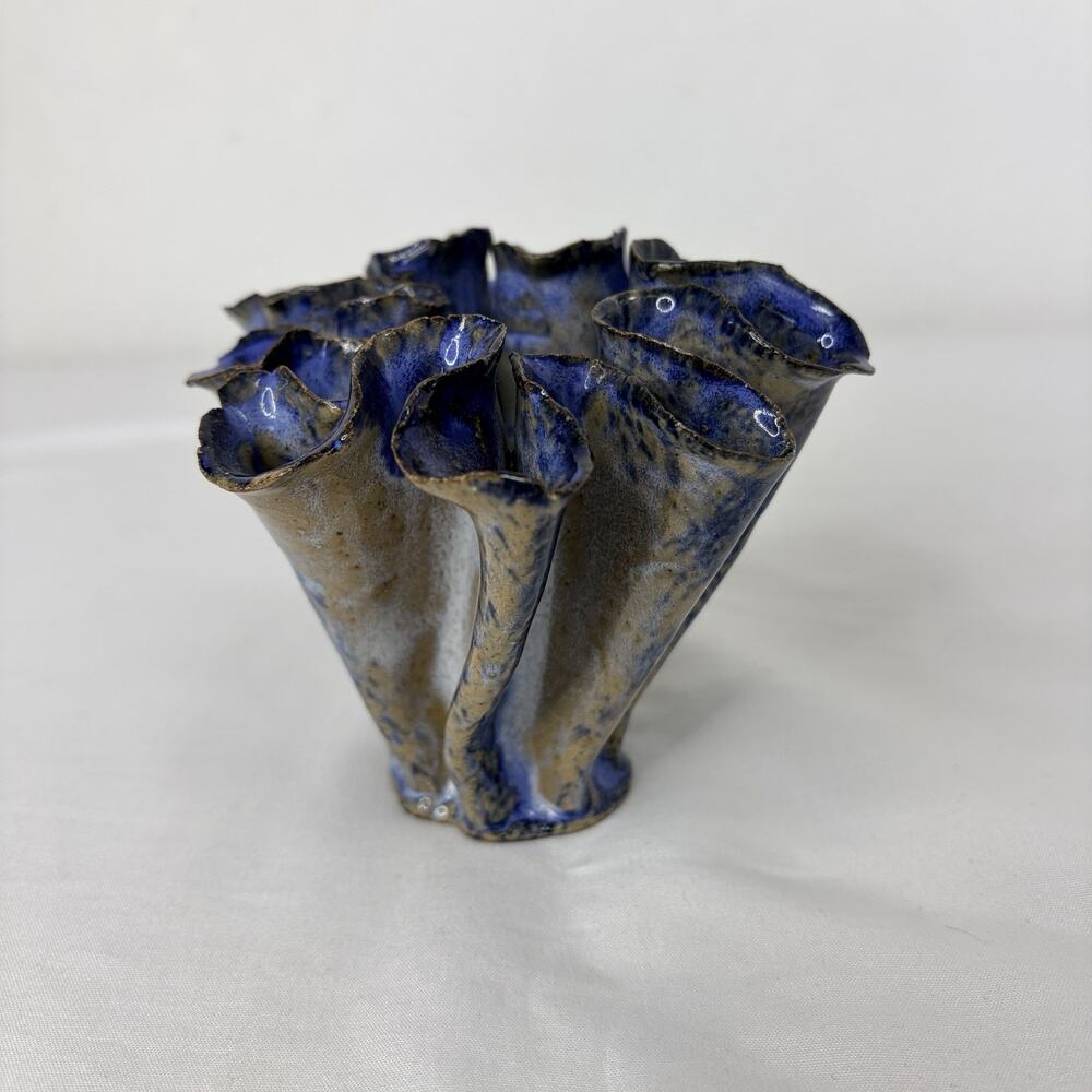 Decorative ceramic vase featuring a unique, organic ruffled shaped blue-glazed